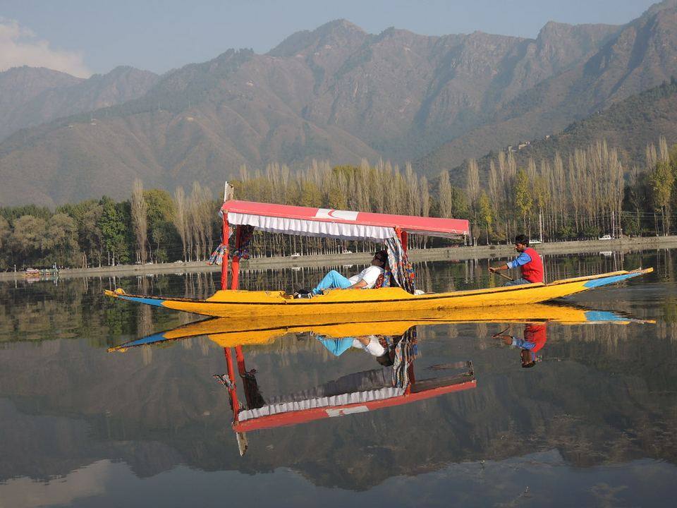 A shikara boat on Dal Lake, Srinagar, with the Kashmir hills behind